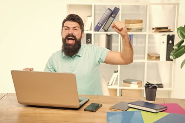 Heyecanlı iş adamı sevinçle bağırıyor. Dizüstü bilgisayarda zafer işareti yapıyor..