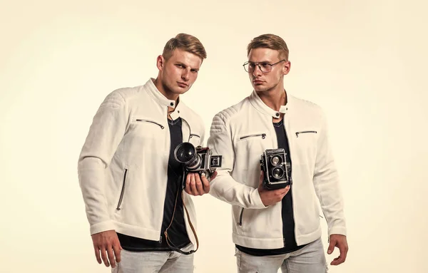 twin brothers men look alike use vintage photo camera, photographing.