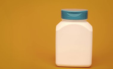 Sarı arka planda multivitamin şişesi. kopyalama alanı. Gıda takviyesi. Vitamin ürünü sunuyorum. beyaz markasız hap kutusu.