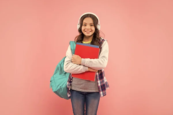 Zadowolony Dzieciak Słuchający Muzyki Słuchawkach Szkolną Torbą Skoroszytem Różowym Tle — Zdjęcie stockowe