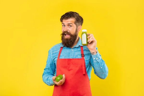 Happy Man Apron Holding Limes Juice Bottle Yellow Background Juicery — Stock Fotó