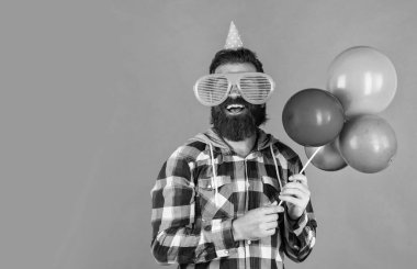 Havalı saç stili olan şık sakallı adam kareli gömlek giyer parti balonları, yıldönümü.