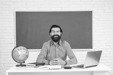 Okula dönüyorum. gayri resmi eğitim. Bilgisayarda çalışan mutlu olgun öğretmen. Sınıfta dizüstü bilgisayarlı kaba sakallı bir adam çalışıyor. Sınava hazırlan. Ders üzerine üniversite öğretim görevlisi.