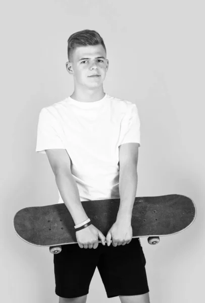 ティーン男の子身に着けていますホワイトカジュアルシャツホールドスケートボード ヒップスター — ストック写真