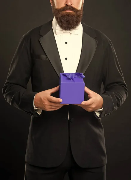 cropped bearded man in tuxedo hold present box, shopping.