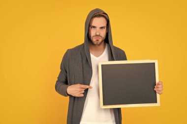 Adam sarı arka planda fotokopi alanı reklamı sunuyor..