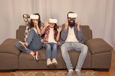 Mutlu aile VR gözlükleri takıyor evdeki koltukta oturuyor, geleceğin teknolojisi..