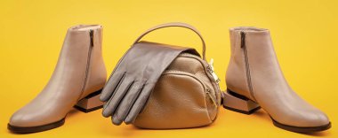 şık deri çizme eldivenler ve sarı arka planda çanta, aksesuarlar..