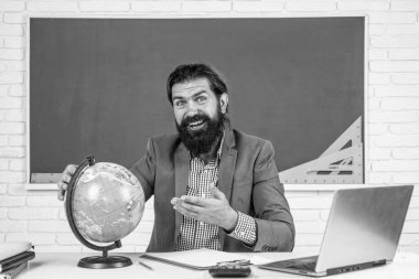 Yeryüzü ve dünya haritası ile sınıflarda coğrafya eğitimi alan öğretmen.