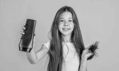 İyi görünüyorsun. Günlük alışkanlıklar ve kişisel bakım. Çocuk şişede şampuan kullanıyor. Saç kremi. Güzellik. Yıka ve durula. Mutlu genç kız kozmetik ürünleri sunuyor. Kuaförde saç şampuanlıyordum..