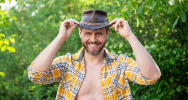 positive west man in cowboy hat. west cowboy in checkered shirt. western cowboy wearing west hat.