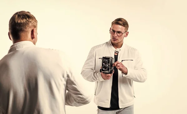 twin brothers men photographer in white casual clothes look alike use vintage photo camera, photographing.