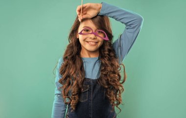 Gözlüklü neşeli komik çocuk. Gençler partiye gider. Parti zamanı. Doğum günü kutlaması. Eğleniyorum. Hadi kutlayalım. Mavi arka planda uzun kıvırcık saçlı çocuk..