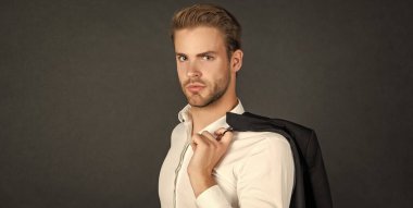 Siyah arka planda saç stili ceketli genç adamın yüzü, erkek güzelliği..