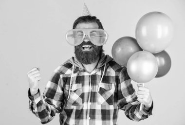 Havalı saç stili olan şık sakallı adam kareli gömlek giyiyor parti balonları tutuyor, kutlama yapıyor..