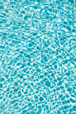 turquoise color background of swimming pool water with ripples. concept of summertime.