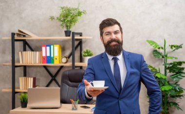 happy mature entrepreneur in jacket having coffee break at office, lunch break.