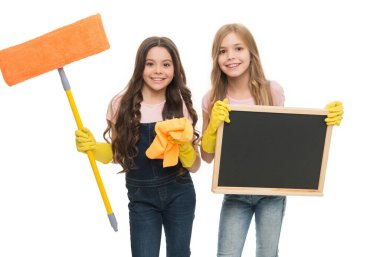 Having fun to work in team. Little schoolgirls enjoy doing cleaning work. Small cleaners in work gloves holding mop and blackboard. All kinds of cleaning work for school, copy space.