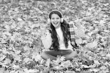 Deliriyorum. çocukluk mutluluğu. Güzellik ve doğa. Mutlu çocuk kulaklık takıyor. Genç kız okula giderken müzik dinler. Çocuk sonbahar ormanında rahatlar. Akçaağaç yaprakları parka düşer. çevrimiçi eğitim.