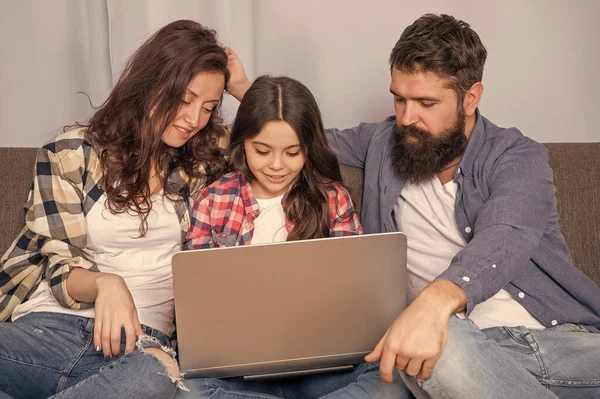 smiling family using laptop at home, education.