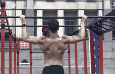 Güç ve motivasyon. Kaslı ve güçlü adam egzersizi. Genç sporcu geliyor. Genç fit adam spor salonunda egzersiz yapıyor. Beyaz tenli genç sporcu şehir dışında. Spor egzersizlerini aç..