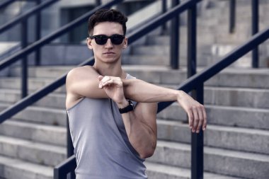 Odaklanmış ciddi sporcu ısınıyor ve kaslarını esnetiyor..