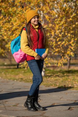 teen girl smile back to school in autumn. full length.