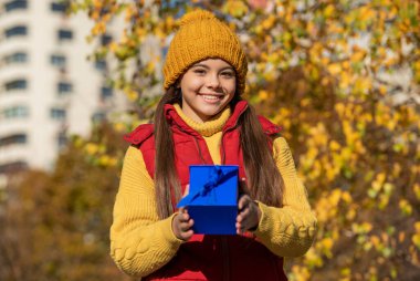 smiling teen girl with present box in autumn.