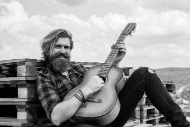 Uzun saçlı hippi ve bıyıklı gitarist. Müzik aleti olan erkek gitarist. Country müzik konsepti. Sakallı adam akustik gitar çalar. Adam insani duygularını ifade ediyor. # Kendini bırak havaya #.