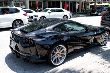 Miami Beach, Florida USA - April 15, 2021: black ferrari F12 berlinetta supercar, side corner view.