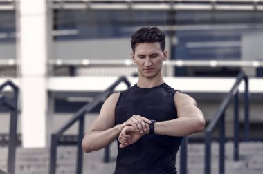 Sağlıklı yaşam ve kendini kontrol kavramı. Formda ve sağlıklı kalmak. Akıllı kalp atış hızı monitörüne bakan sporcu akıllı saat. Trail koşucusu kalp atış hızı monitörü saatine bakıyor.