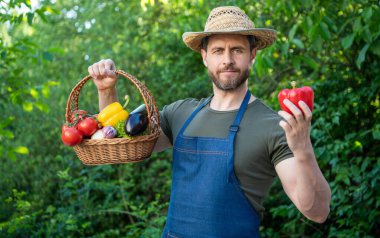 man in straw hat hold basket full of vegetables. crop.