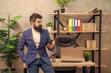 Bağlanmanın basit bir yolu. İş yerinde akıllı telefon kullanan ciddi bir adam. Akıllı telefon iletişimi. SMS mesajı. İş sohbeti.