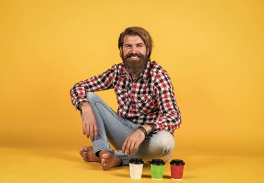 Hoş gülümseme. Kahveli yakışıklı hippi adam. Kahve molası veriyor. Fincandan su içen yakışıklı bir yetişkin. Bir fincan kahve ya da çay al. yaşam tarzı konsepti.