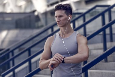 Eğitim ve yaşam tarzı konsepti. Kalp atış hızı olan bir koşucu spor akıllı saatini izliyor. Saate bakıyorum. Spor salonunun dışında sıkı antrenman. Bilek temelli kalp atış hızı monitörü. Çalıştırılan zamanı kontrol ediyorum.