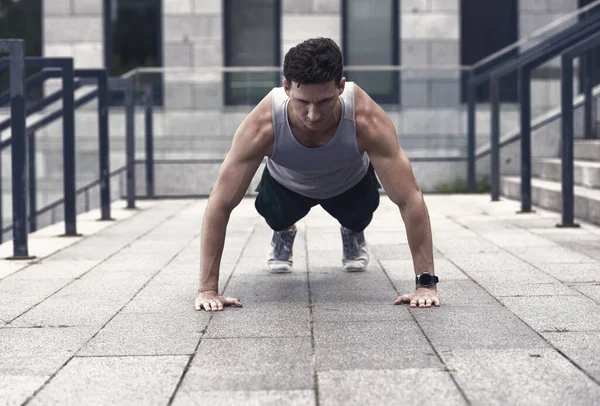 Şınav çeken atletik adam, şehir sporu konsepti.