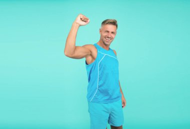 glad sport athlete making winning gesture. Athlete winner blue background. sport man celebrating victory, athlete.