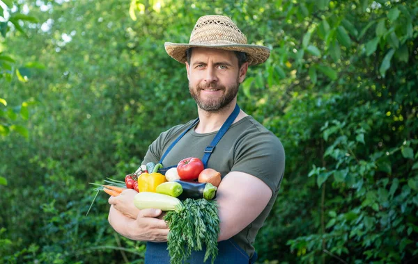 man in straw hat hold fresh ripe vegetables.