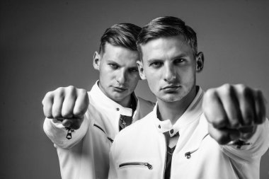 Benzer görünüşlü genç ikiz kardeşler yumruk ve güç gösterisi yapıyorlar..