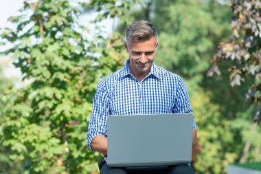 smiling man working online. man freelancer working online outdoor. online business blog.