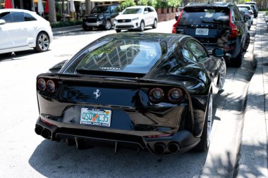 Miami Beach, Florida USA - April 15, 2021: black ferrari F12 berlinetta supercar, side back view.