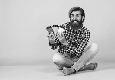 Kafe reklamı. Kahve molası veriyor. Yakışıklı, olgun bir adam içki içiyor. Bir fincan kahve ya da çay al. Yaşam tarzı konsepti. Bir fincan kahveli hippi adam. Kopyalama alanı.