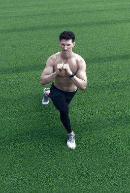 Spor salonundaki adam dışarıda çalışıyor. İnsan vücudunu eğitmek. Kaslı vücutlu bir adam. Sportif insan dışarıda esneme hareketleri yapıyor. O kasları esnek tutmak. Harika bir ısınma. Formda ve sağlıklı kalmak..