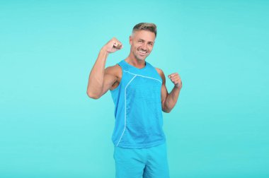 Happy sport athlete making winning gesture. athlete winner blue background. sport man celebrating victory, athlete.