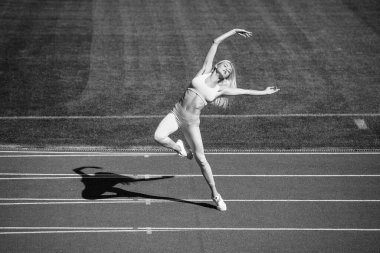 Seksi fitness kadını stadyumda spor kıyafetleri giyiyor, esneklik var..