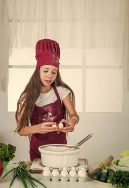 Mutlu çocuk aşçı üniforması giyer. Şapkalı ve önlüklü şef kız. Çocuk mutfakta yemek pişiriyor. Kariyer seçmeyi. Küçük yardımcı pişirme. Mutfak ve mutfak. Mutlu çocukluk. Zevk mükemmellikle buluşur..