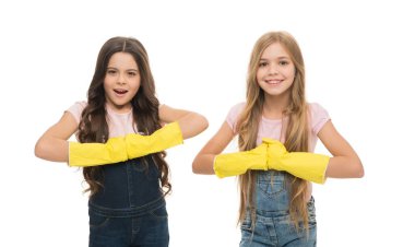 Household duties. Little helper. Girls cute kids love cleaning around. Keep it clean. Protect sensitive skin. Kids cleaning together. Girls with yellow rubber protective gloves ready for cleaning.