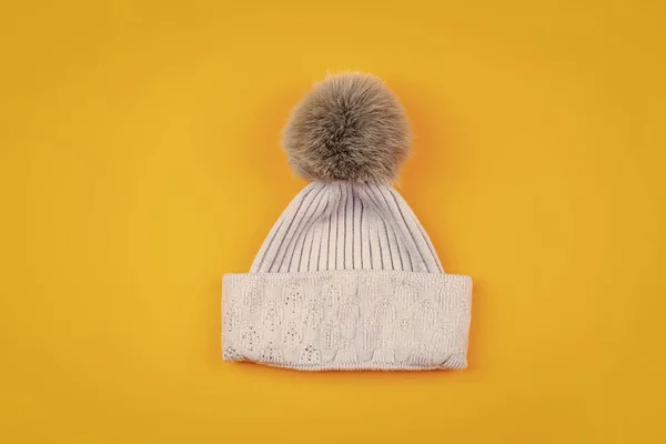 warm clothes. winter fashion. knitted winter beanie hat on yellow background.