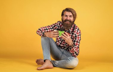 Arkadaşlara içki. Günaydın. Evde sabah havası var. İlham konsepti. Hipster adam kahve içer. Beyaz bardak tutan yakışıklı sakallı adam. Bardakla içecek. Çay ya da kahve içmek..