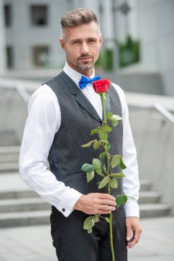 valentines day concept. handsome tuxedo man with valentines rose. flower gift for valentines day.
